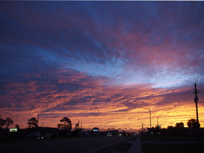 [The orange portion of the prior photo is now mostly yellow. Above the yellow are yellow tinged purple clouds with blue sky above that.]